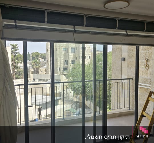 תריסים פתוחים עם אדם וסולם ליד חלון גדול